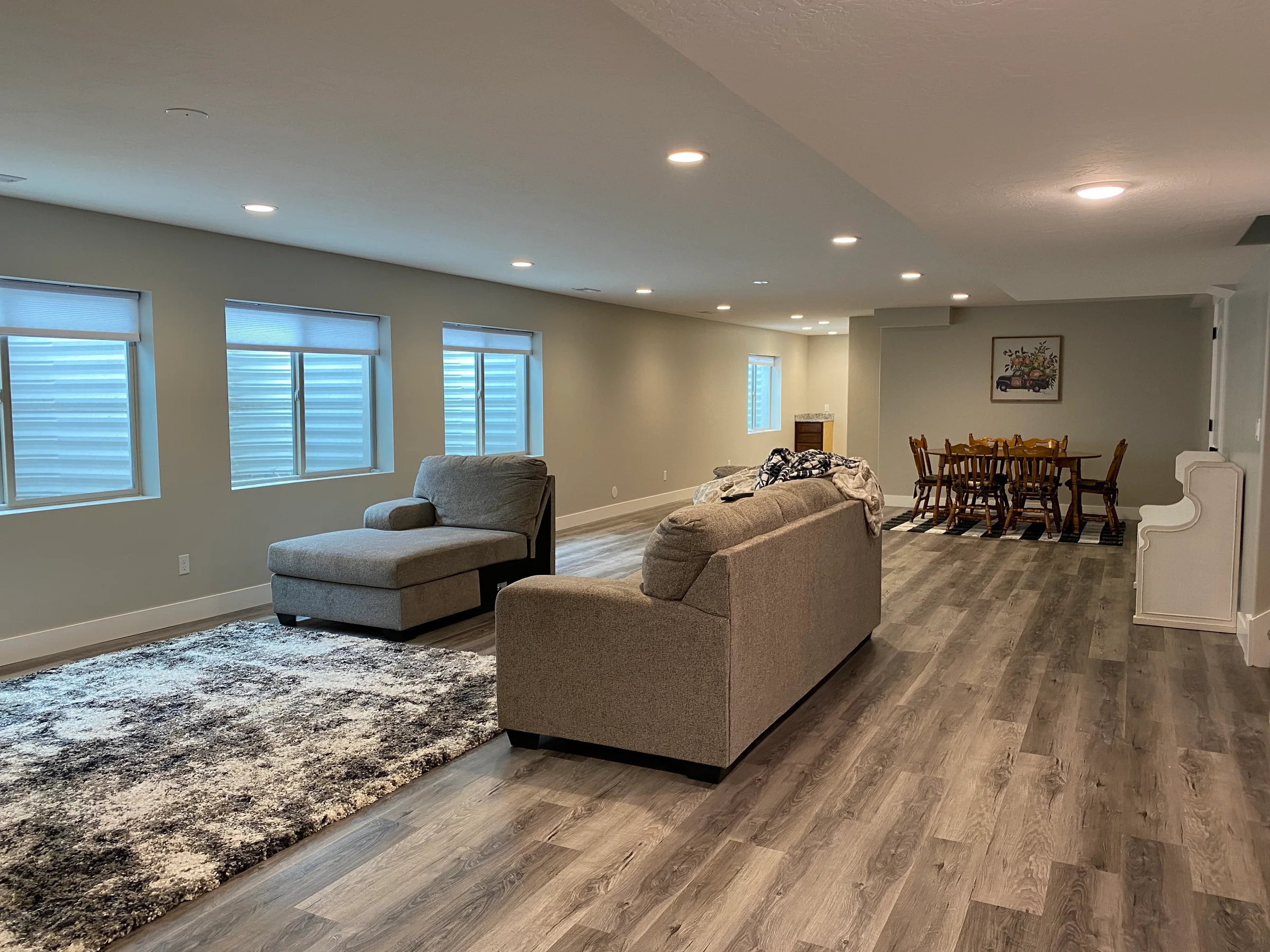 Finished basement living and dining area with freshly painted light walls.