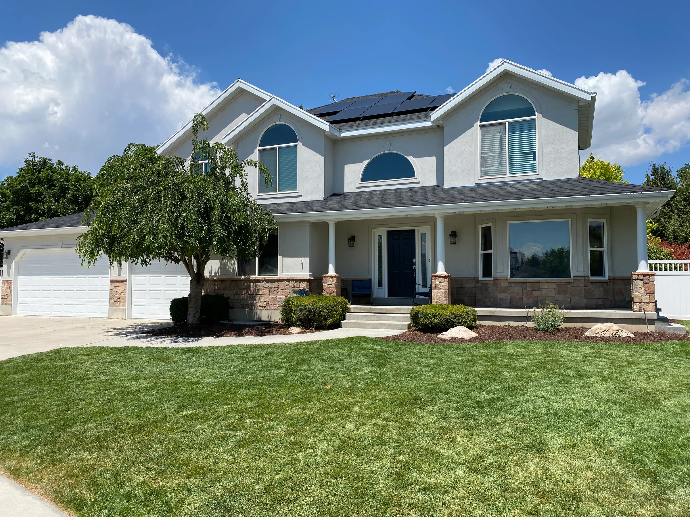 Two-story home with blue-gray siding, white trim and a covered front porch.