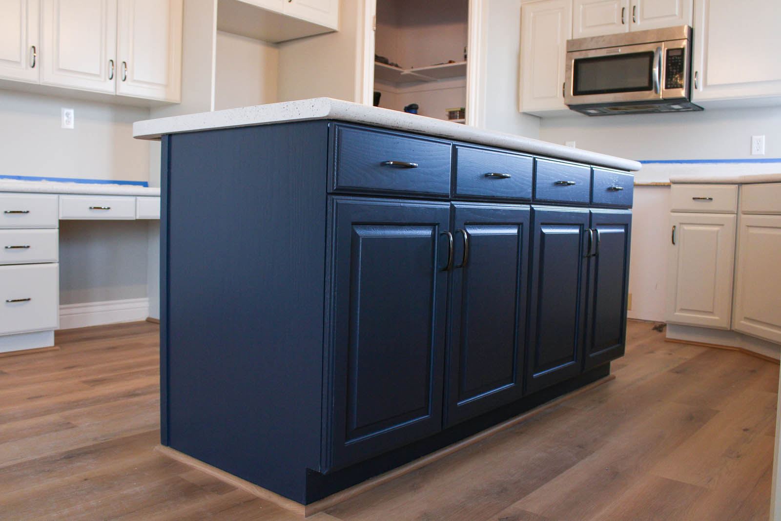 Dark blue island doors beneath a pale counter