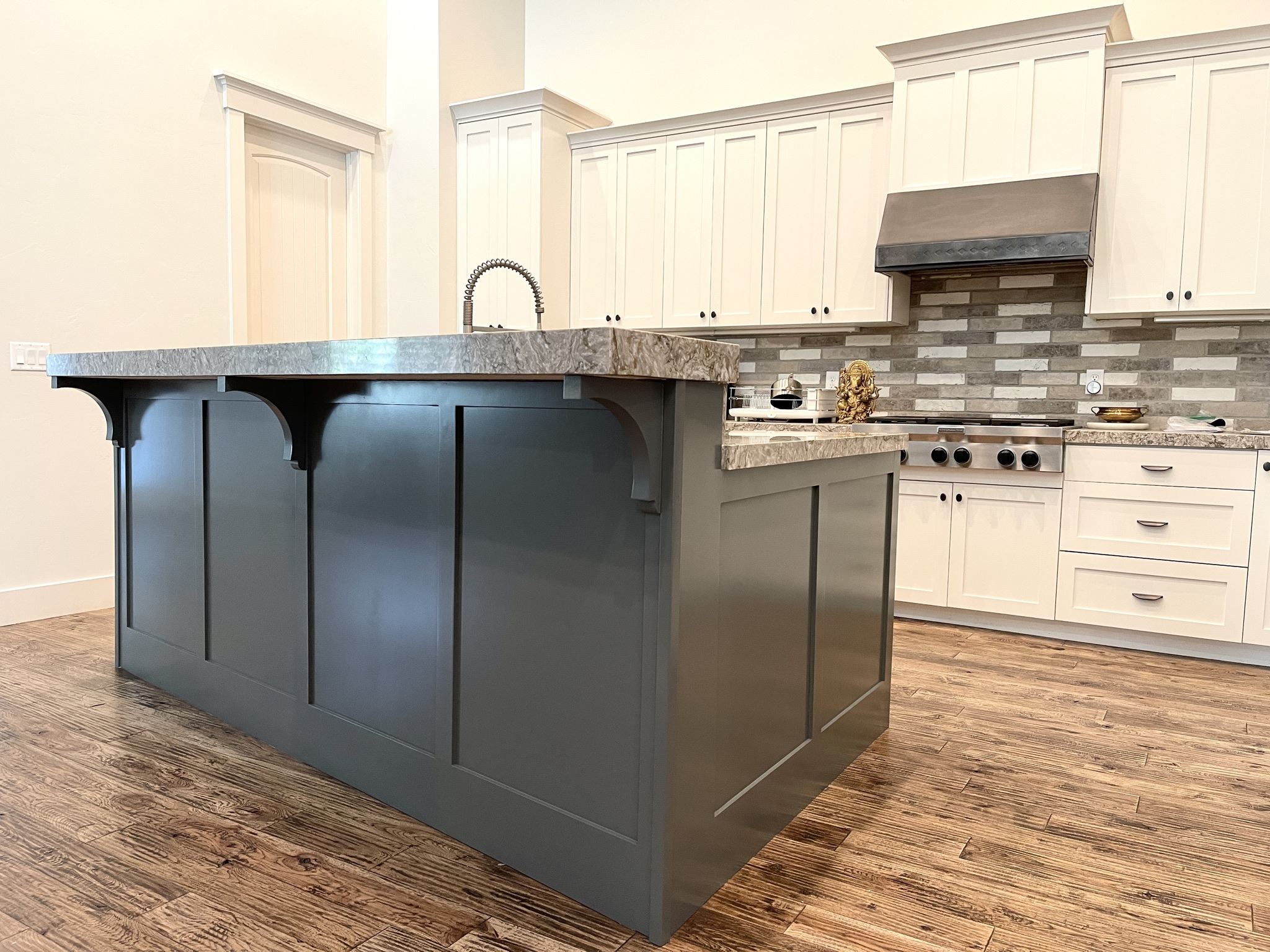 Dark blue kitchen island beside white cabinets
