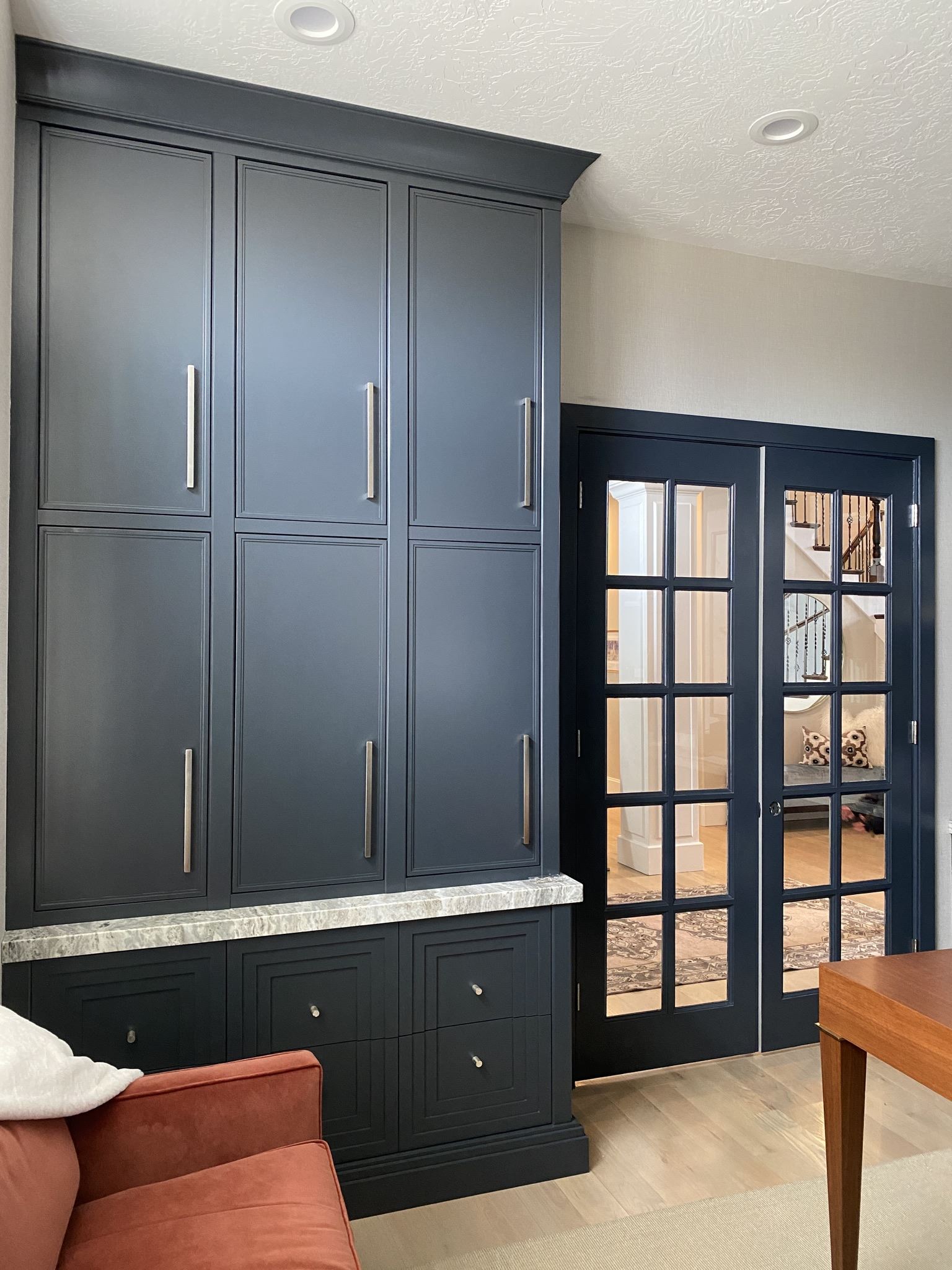 Dark built-in cabinets beside a glass-paneled door