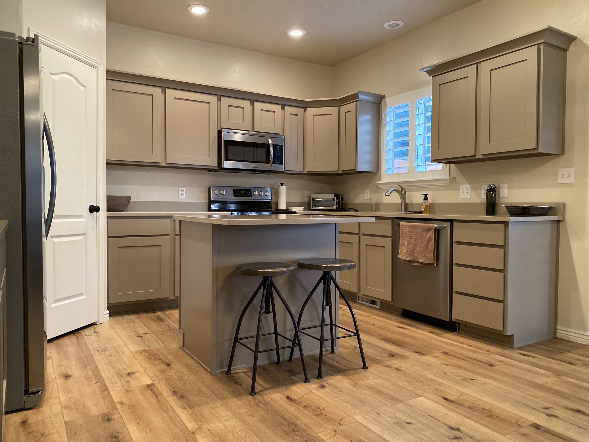 Gray kitchen cabinetry around a range and microwave