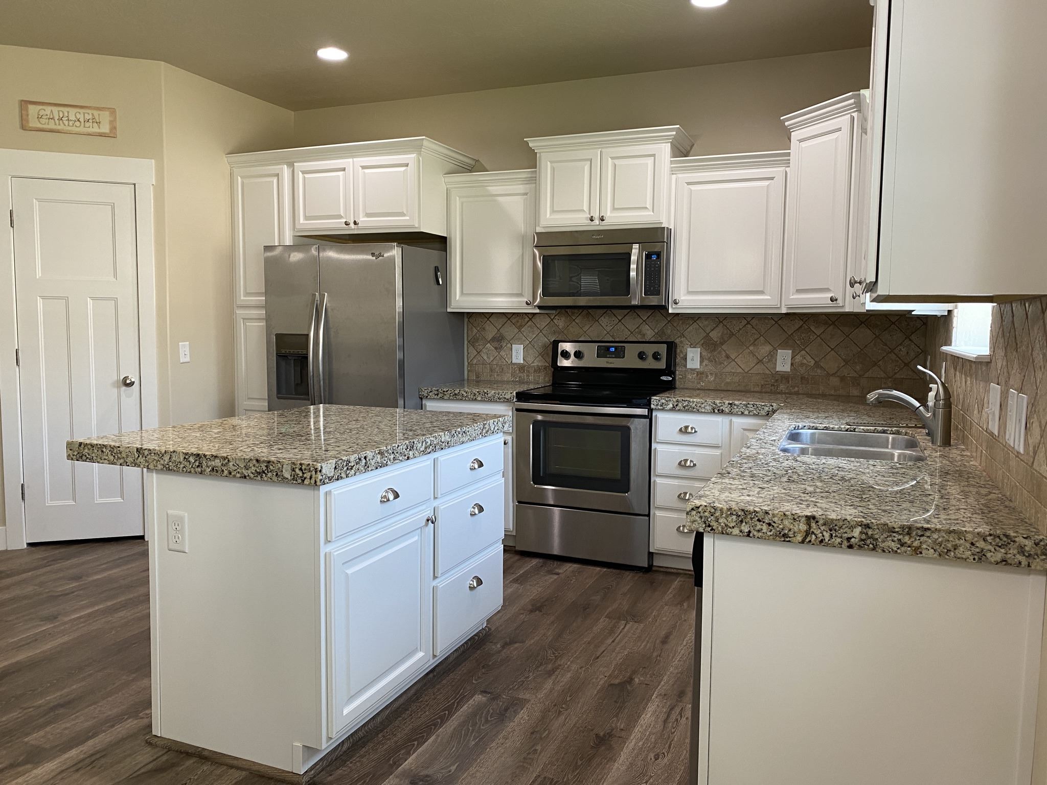 White cabinets beside a patterned backsplash