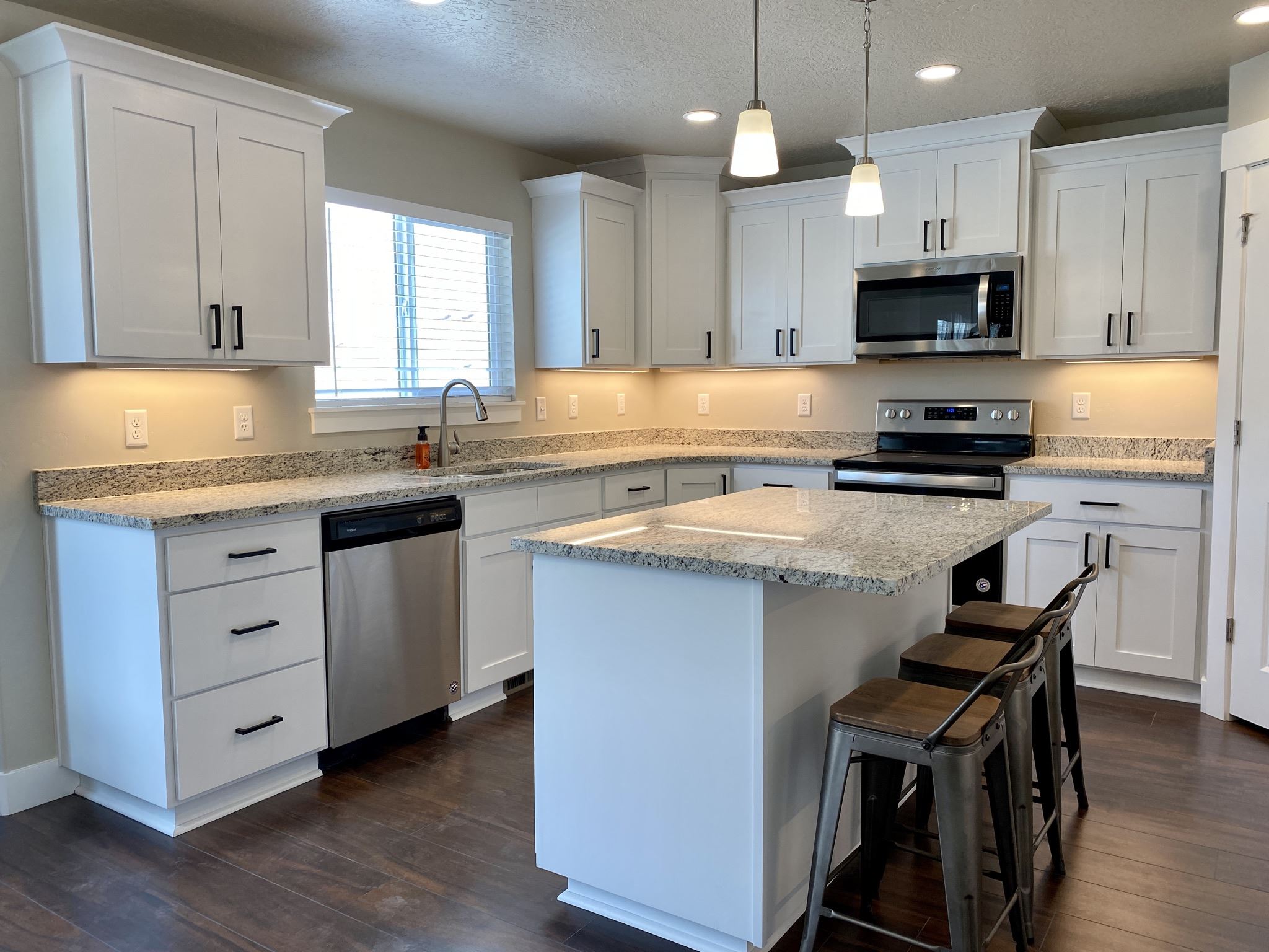 White kitchen cabinetry around a stainless steel range