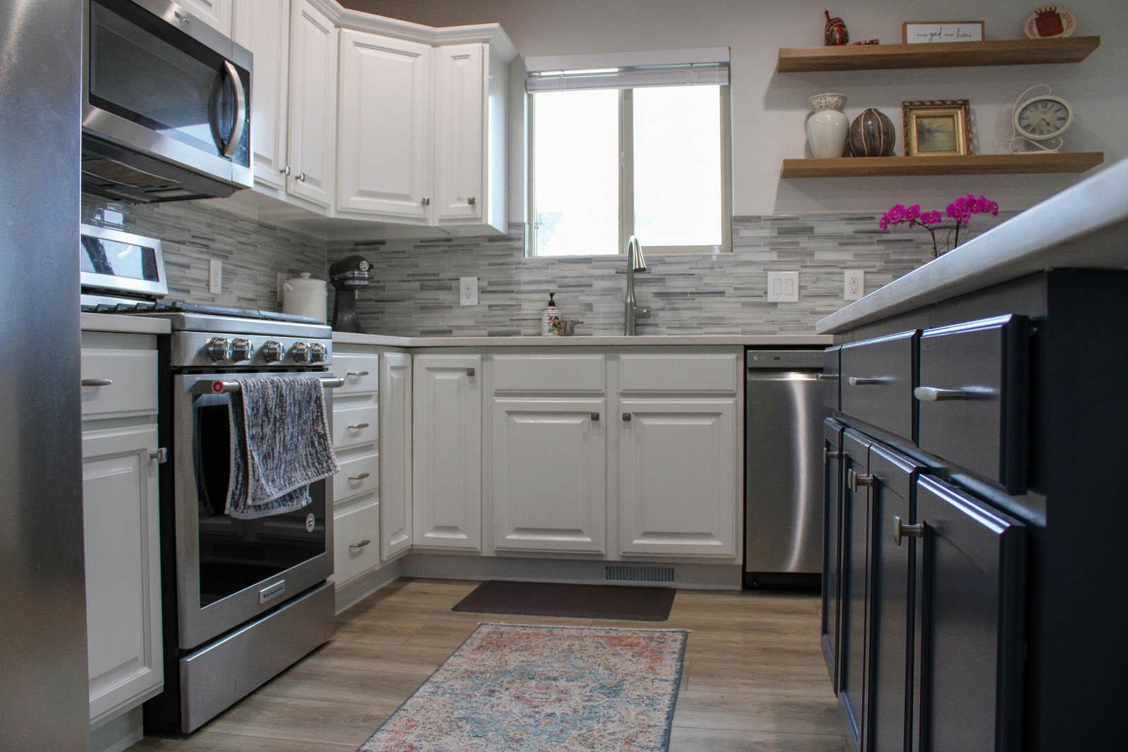 White kitchen cabinets around a window and sink