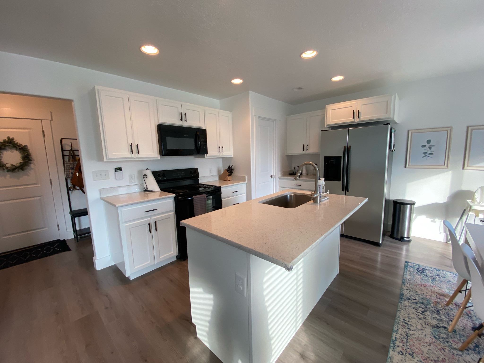White kitchen cabinets with a pale island