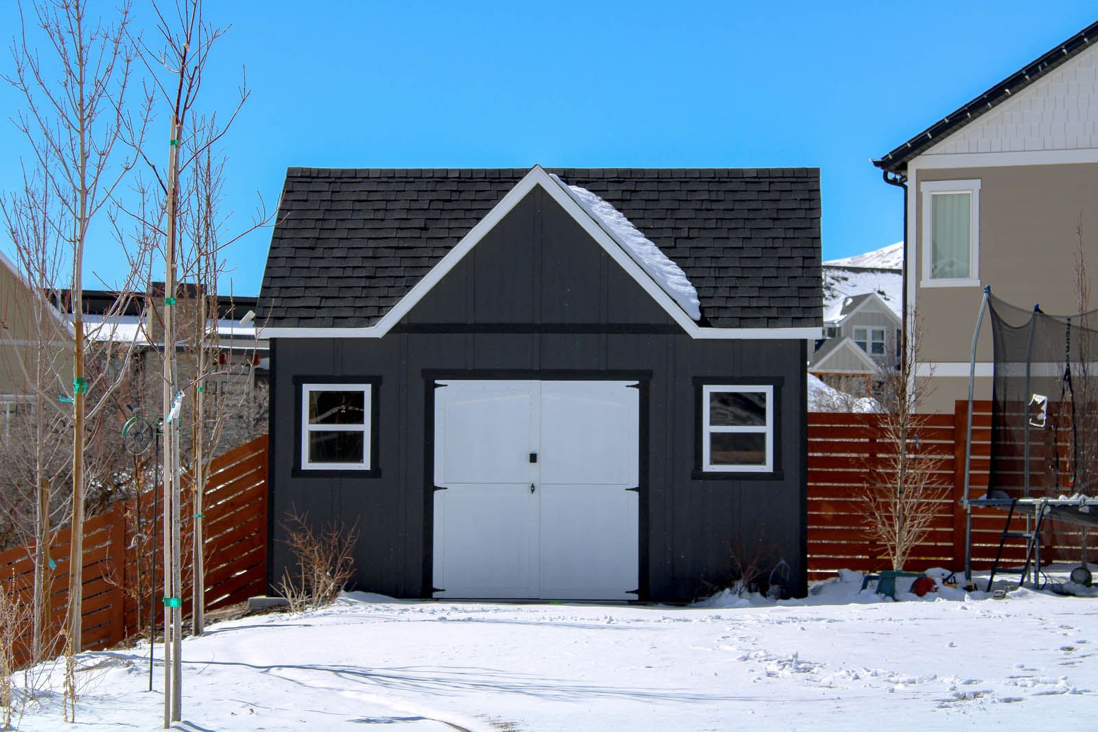 Dark garage exterior with white trim in winter