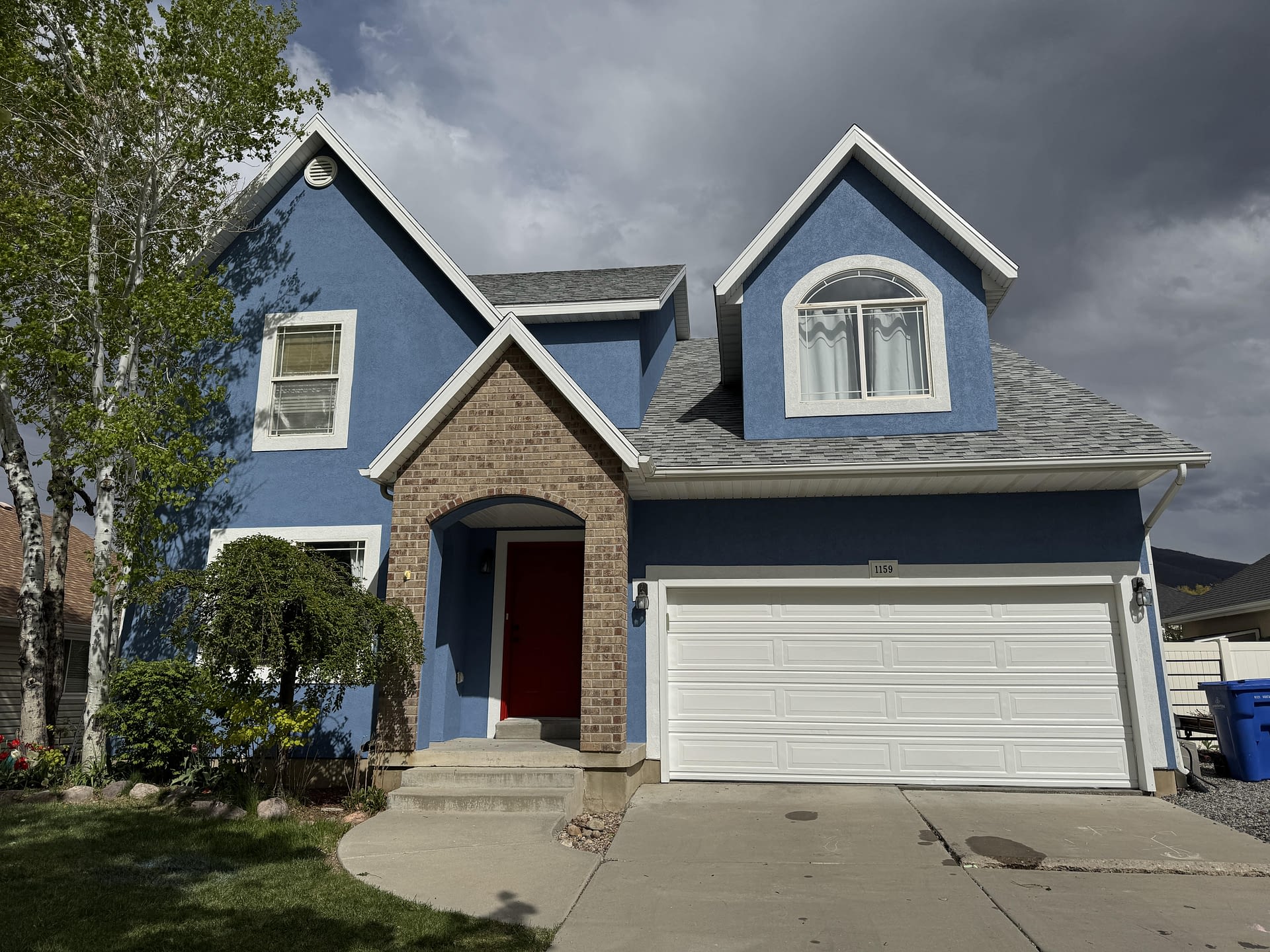 House facade with blue-gray siding and garage