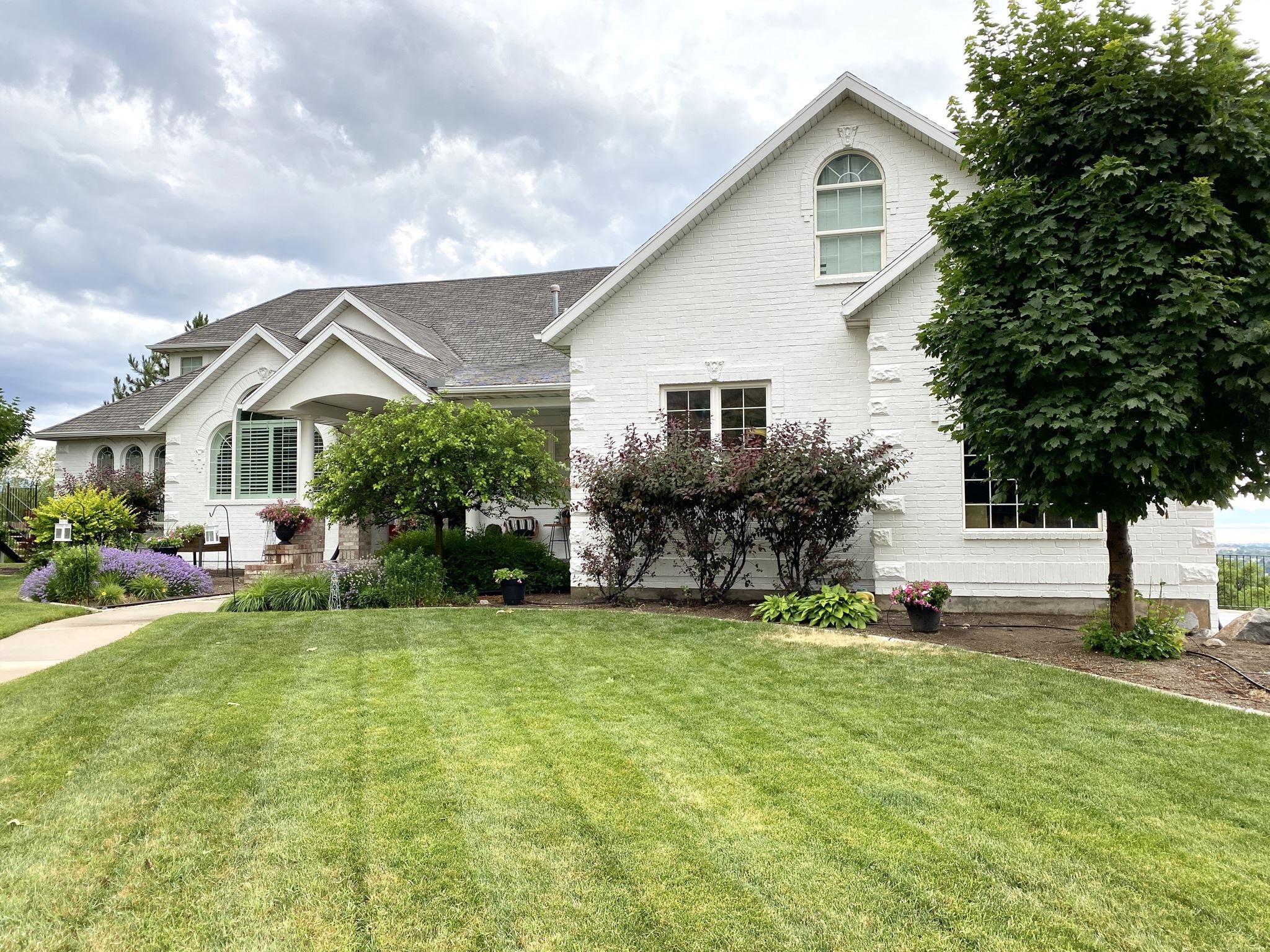 Light home exterior with porch and landscaping