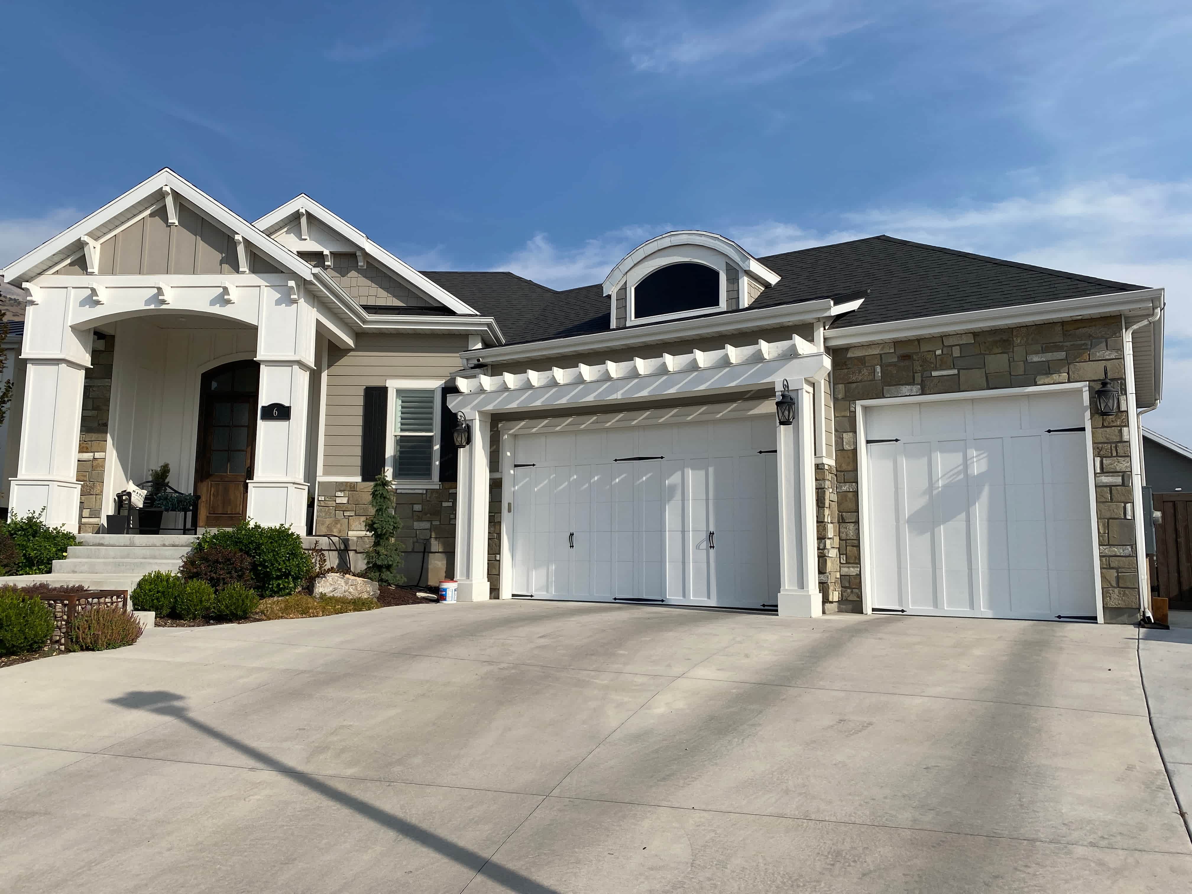 Light home exterior with stone accents and garage